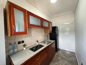 a small kitchen with a sink and a refrigerator at Bonapriso in Douala
