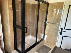 a shower with a glass door in a bathroom at Bonapriso in Douala +3 photos