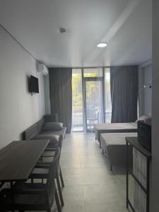 a hotel room with beds and a table and chairs at Sunny Gardens in Shekhvetili