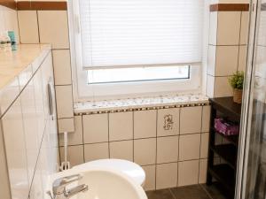 a bathroom with a sink and a window and a toilet at Ferienwohnung Burgstadt Kastellaun in Kastellaun