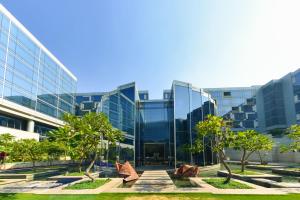 a glass building with trees in front of it at Andaz Delhi, by Hyatt in New Delhi