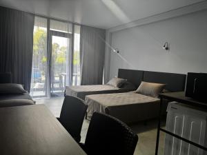 a hotel room with two beds and a window at Sunny Gardens in Shekhvetili