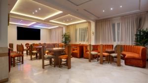 a conference room with tables and chairs and a flat screen tv at Intouriste Hotel & Suites in Agadir