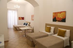 a room with two beds and a couch and a table at Sorrentina Guest House in Sorrento