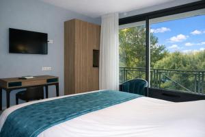 a hotel room with a bed and a large window at Le Clos De Mutigny in La Chaussée-sur-Marne