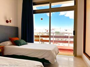a bedroom with two beds and a large window at Brisamar Canteras in Las Palmas de Gran Canaria +91 photos