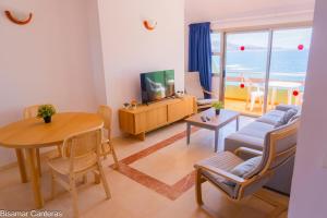 a living room with a couch and a table and a television at Brisamar Canteras in Las Palmas de Gran Canaria