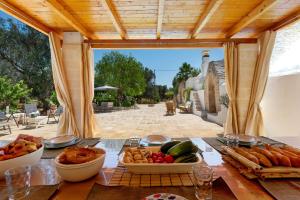 a table with bowls of food on a patio at Trullo Sobba Llera by BarbarHouse in San Michele Salentino