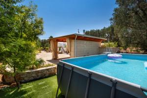 a swimming pool in a yard with a gazebo at Trullo Sobba Llera by BarbarHouse in San Michele Salentino