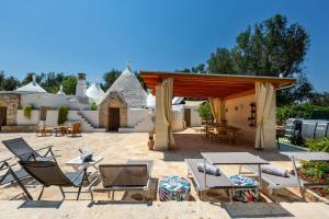 a patio with chairs and tables and a pavilion at Trullo Sobba Llera by BarbarHouse in San Michele Salentino