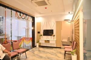 a lobby with a tv and chairs and a room at Hotel Radian INN in Gorakhpur
