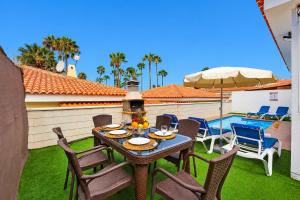 a patio with a table and chairs and a pool at CHALET 273 con PISCINA PRIVADA in Callao Salvaje