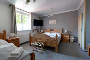 a bedroom with a bed and a chair in it at Penzion Janoštík in Rožnov pod Radhoštěm