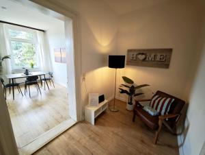 a living room with a table and a chair and a lamp at Tolle Moderne Altbau Wohnung in Hohenlockstedt