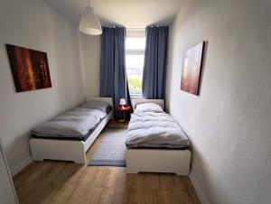 two beds in a room with a window at Tolle Moderne Altbau Wohnung in Hohenlockstedt