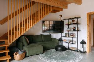 a living room with a green couch and a staircase at Výtoň 263 in Přední Výtoň