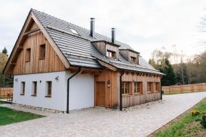 a large wooden barn with a white garage at Výtoň 263 in Přední Výtoň