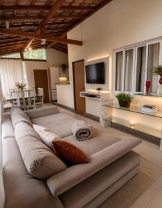 a living room with a large couch and a television at Pousada Jupter in Teresópolis