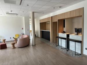 an office lobby with a chair and a desk at B&B HOTEL Amiens Sud in Amiens