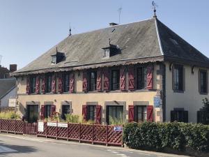 a building with red shuttered windows and a roof at A l'Aube des Volcans in Charbonnières-les-Vieilles