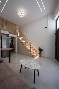 ein Wohnzimmer mit einem Tisch und einer Treppe in der Unterkunft Estia Loft in Giannitsa