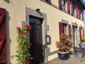 a door with flowers on the side of a building at A l'Aube des Volcans in Charbonnières-les-Vieilles +14 photos