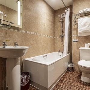 a bathroom with a tub and a sink and a toilet at The Old Bridge Inn, Holmfirth, West Yorkshire - The Coaching Inn Group in Holmfirth +28 photos