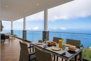 a table with food on top of a balcony at Villa Sea Colors by An Island Apart in Arco da Calheta