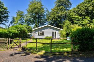 a small white house with a wooden fence at Finest Retreats - Brockwood in Bradworthy