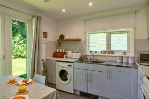 a kitchen with a sink and a washing machine at Finest Retreats - Brockwood in Bradworthy