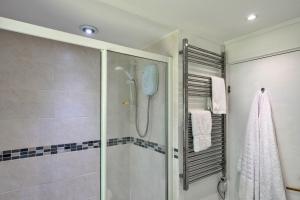 a bathroom with a shower with a glass door at Finest Retreats - Brockwood in Bradworthy +23 photos