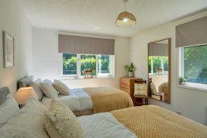 a bedroom with two beds and a couch and a mirror at Finest Retreats - Brockwood in Bradworthy