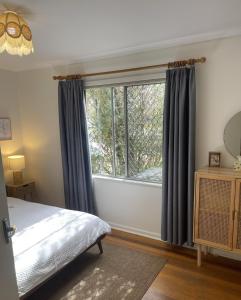 a bedroom with a bed and a large window at Barossa Suites on Basedow in Tanunda