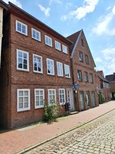 a brick building with white windows on a street at Ferienwohnung Till in Mölln