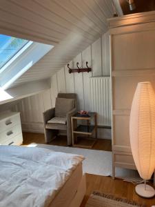 a attic bedroom with a bed and a chair at Villa Angela, appartement 3 chambres in Ovifat