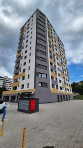 a large tall building in front of a parking lot at MyPlace apartmani 42,56,70 in Tuzla +1 photo