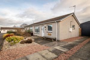 a small white house with a driveway at Driftwood - Crail in Crail
