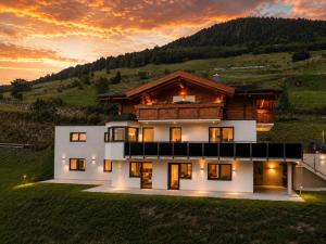 a house on a hill with the sunset in the background at Bergdiamant Nauders in Nauders