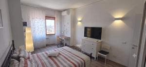 a white bedroom with a bed and a television at Alloggio per uso Turistico Capone Alessia - A DUE PASSI DAL CENTRO in Viterbo