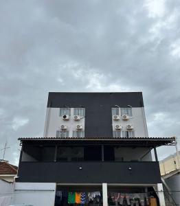 a black and white building with windows on it at BG Hospedagens in Paracatu