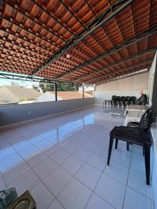a swimming pool with chairs and a table in a room at BG Hospedagens in Paracatu