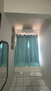 a bathroom with a blue shower curtain and a mirror at BG Hospedagens in Paracatu