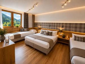 a hotel room with two beds and a window at Bergdiamant Nauders in Nauders
