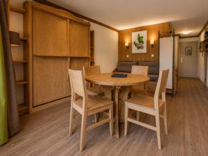 a dining room with a wooden table and chairs at Val d'Isère Centre - Emplacement Idéal in Val-d'Isère +5 photos