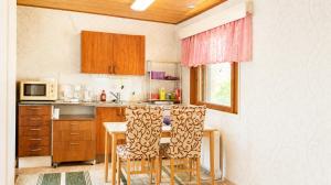 a kitchen with a table and chairs and a microwave at Lakeuden Sydän in Kauhajoki