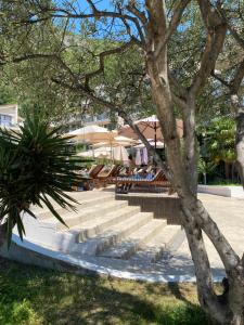 a group of stairs with tables and a tree at Eva in Pržno