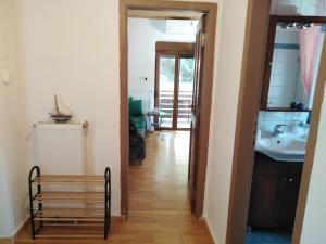 a hallway leading to a bathroom with a sink and a mirror at Eternal blue in Volos