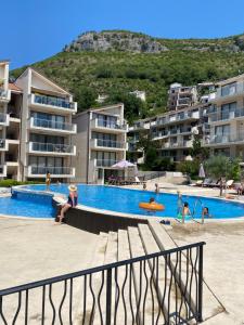 a group of people in a swimming pool with buildings at Eva in Pržno