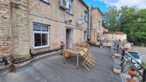 a patio with a wooden table in front of a brick building at Apartment SKAISTUMS in Jūrmala