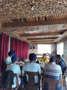 a group of people sitting at a table in a restaurant at Kashmir Beautiful Villa in Srinagar